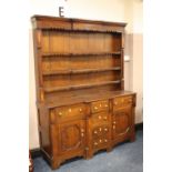 A 19TH CENTURY OAK WELSH DRESSER, the plate rack with shaped frilled frieze and shelves,with