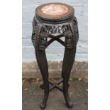 AN ORIENTAL CARVED HARDWOOD JARDINIERE STAND, with circular inset marble panel, H 92.5 cm