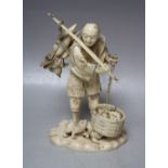 A JAPANESE IVORY OKIMONO, depicting a fruit seller holding a rod over his shoulder with his