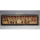 AN ORIENTAL CARVED AND GILT WOOD RECTANGULAR PANEL, modelled as figures carved in relief around a