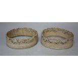 A PAIR OF 19TH CENTURY CARVED IVORY COASTERS, of oval outline, with pierced carved sides, Dia. 9