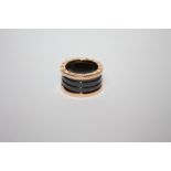 A BVLGARI 18CT ROSE GOLD FOUR BAND RING, the ring with black sprung ceramic spiral design to the