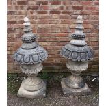 A PAIR OF LARGE STONE PEDESTAL URNS, supported on a squared foot leading to a solid swirling base,