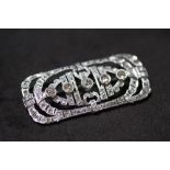 AN EDWARDIAN PLATINUM DIAMOND BROOCH WITH FILIGREE DESIGN, in a vintage box. Set with 5 graduated
