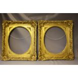 A PAIR OF MID 19TH CENTURY DECORATIVE GILT FRAMES WITH CORNER EMBELLISHMENTS AND OVAL SPANDRELS,
