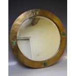 AN EARLY 20TH CENTURY ARTS AND CRAFTS CIRCULAR COPPER WALL MIRROR WITH FOUR OVAL GREEN STONE