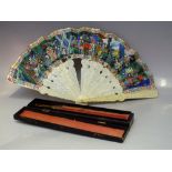 AN ANTIQUE ORIENTAL CARVED IVORY DECORATIVE FOLDING FAN, with profuse carving to both the guards and