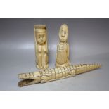 A PAIR OF EARLY 20TH CENTURY CARVED IVORY TRIBAL HEADS, together with an ivory carved crocodile, L