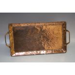 AN ARTS AND CRAFTS RECTANGULAR TWIN-HANDLED TRAY BY JOHN PEARSON, of typical hammered finish,