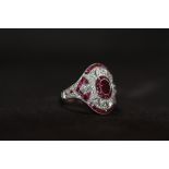 AN ORNATE PLATINUM RUBY AND DIAMOND DRESS RING, Set with an oval-cut ruby, calibre-cut rubies and