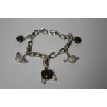 A THEO FENNELL OF LONDON 18CT WHITE GOLD AND DIAMOND BRACELET WITH FIVE ASSORTED JEWELLED CHARMS,