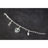 CARTIER - AN 18 CARAT WHITE GOLD DIAMOND SET CHARM BRACELET, set with three charms including a