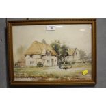 A GILT FRAMED AND GLAZED WATERCOLOUR OF A FIGURE FEEDING CHICKENS BY A COTTAGE SIGNED H CUBBERLY