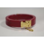 LOUIS VUITTON - A RESIN 'LOCK ME' HINGED BANGLE, with original box and Louis Vuitton drawstring bag