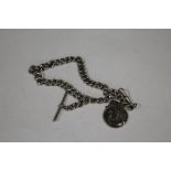 AN ANTIQUE SILVER POCKET WATCH CHAIN WITH SILVER FOOTBALL INTEREST FOB