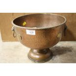 AN UNUSUAL HAMMERED FINISH COPPER TWIN HANDLED FOOTED BOWL WITH GEORGIAN COINS TO OUTER EDGE,