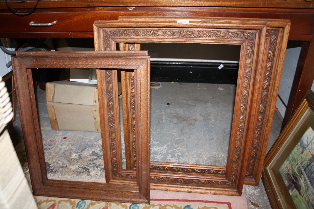 A PAIR OF CARVED OAK PICTURE FRAMES TOGETHER WITH A PAIR OF SMALL OAK PICTURE FRAMES