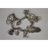 A HALLMARKED SILVER CHARM BRACELET - APPROX WEIGHT 50G