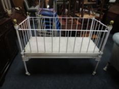 AN ANTIQUE METAL AND BRASS BABYS COT BED WIT DROP DOWN SIDE, W 128 cm