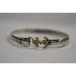 A WHITE AND YELLOW METAL BANGLE STAMPED STERLING 14K WITH ANCHOR SHAPED CLASP APPROX WEIGHT - 15.3G