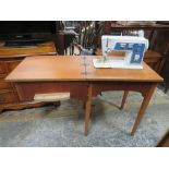 A SINGER ELECTRIC SEWING MACHINE IN TABLE