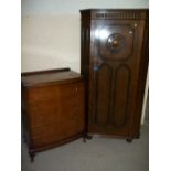 AN OAK LOCKING HALL CUPBOARD AND A BOW FRONTED CHEST OF FIVE DRAWERS