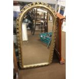 A GILT FRAMED ARCH SHAPED MIRROR, APPROX. 86 X 49 CM