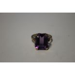 A 9 CT GOLD DRESS RING SET WITH LARGE PURPLE STONE
