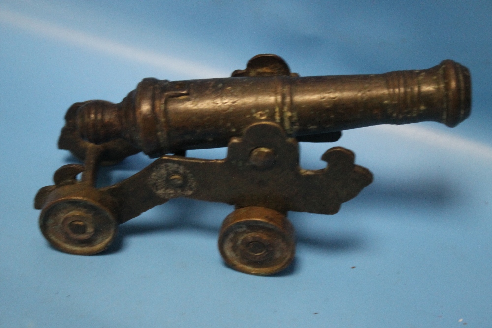 A SMALL ANTIQUE SIGNAL CANNON ON SHEET METAL CARRIAGE