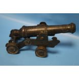A SMALL ANTIQUE SIGNAL CANNON ON SHEET METAL CARRIAGE