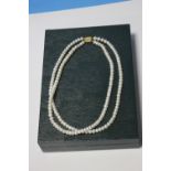 A TWO STRAND ERNEST JONES PEARL NECKLACE WITH A 9 CT GOLD CLASP