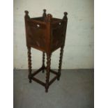 AN ANTIQUE OAK PLANT STAND WITH BARLEY TWIST DETAIL