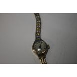 A LADIES 9 CT GOLD UNO WRIST WATCH ON PLATED STRAP