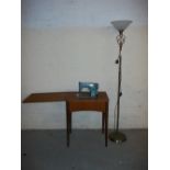 A SINGER SEWING MACHINE AND TABLE WITH A FLOOR STANDING LAMP