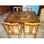 AN EARLY 1900S DRAW LEAF OAK DINING TABLE WITH FOUR CHAIRS