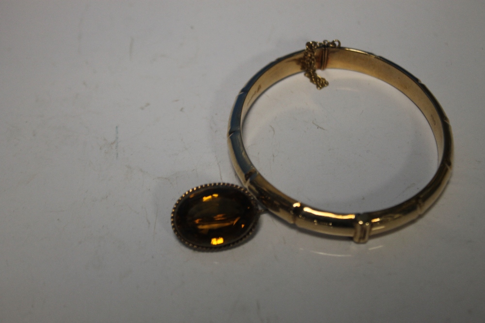 A 9 CT GOLD HINGE BANGLE (w 11 g) ALONG WITH A SMALL YELLOW METAL BROOCH