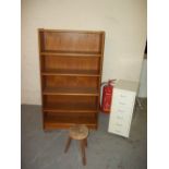 A RETRO TEAK BOOKSHELF, A MILKING STOOL AND A TOOL CABINET