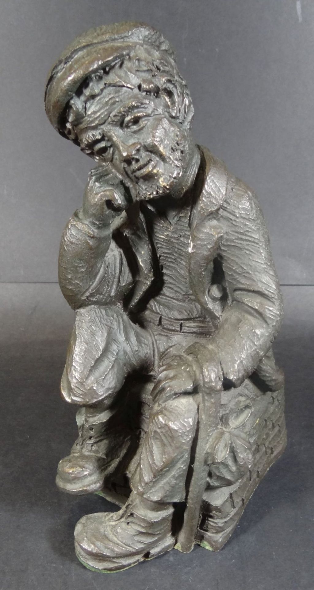 Figur eines sitzenden Landstreichers, Kunstmasse, rückseitig undeutl. gemarkt, H-22 cm, 14x10 c