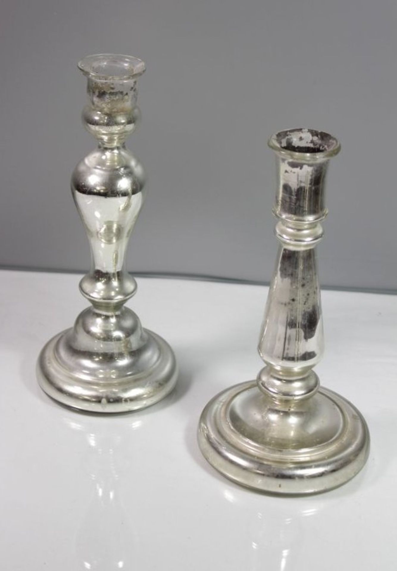 Paar untersch. Leuchter, Bauernsilber, um 1900, je mit Alters-u. Gebrauchsspuren, H-26cm u. 24,5cm.