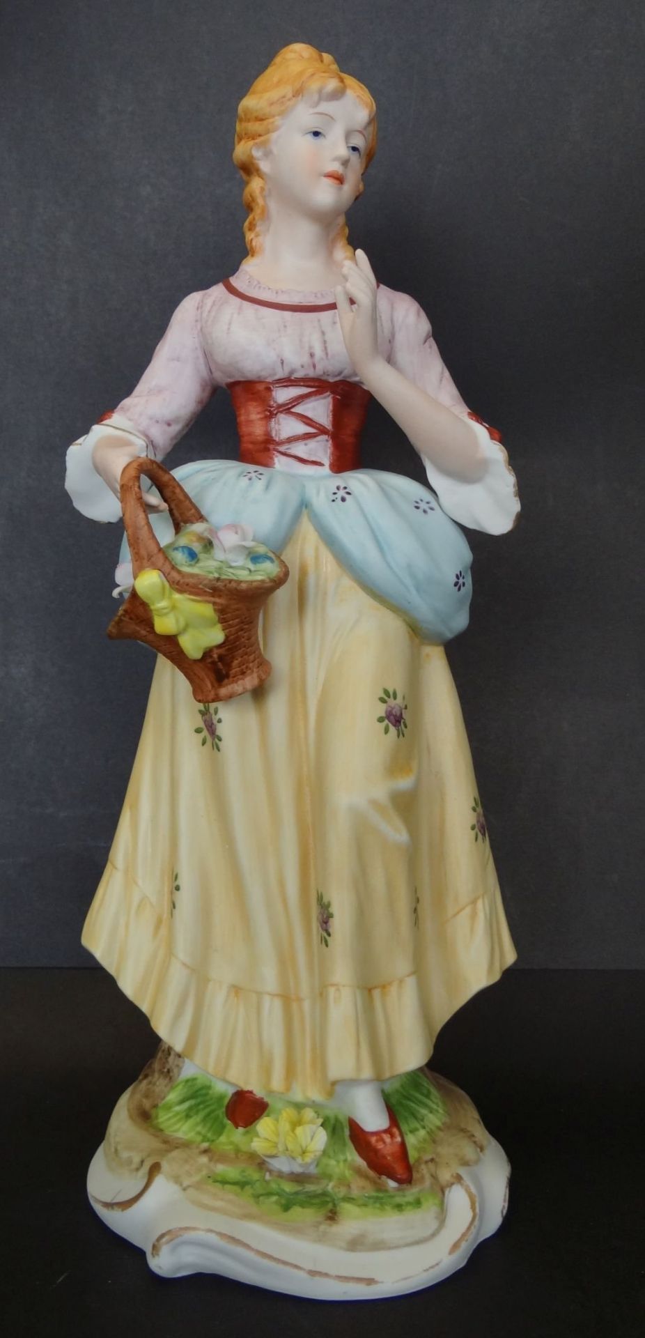 hohe Bisquitporzellan-Figur "Mädchen mit Blumenkorb", ein Daumen beschädigt, linke Hand geklebt,
