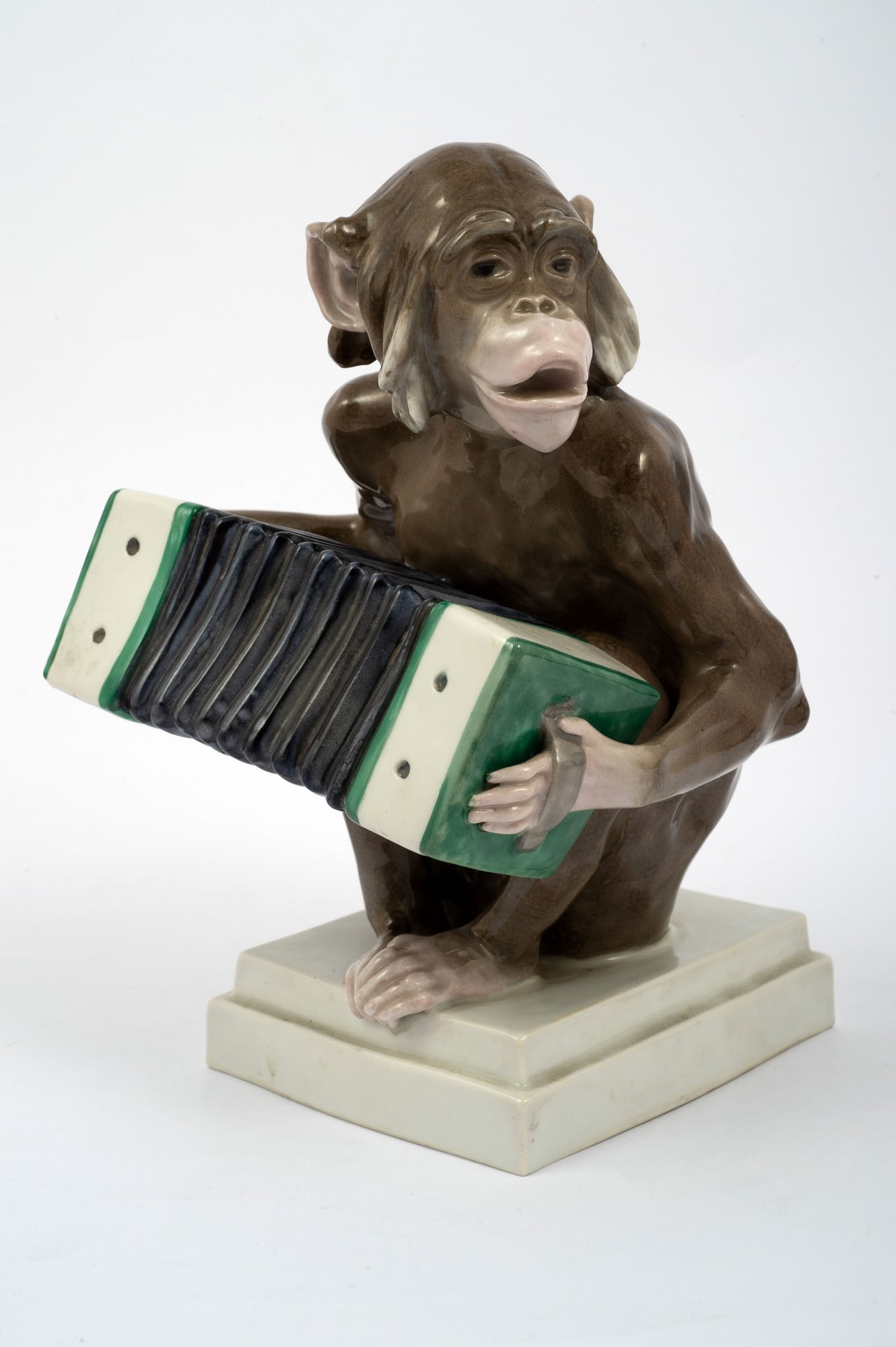 Polychrome porcelain sculpture depicting monkey playing