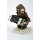 Polychrome porcelain sculpture depicting monkey playing