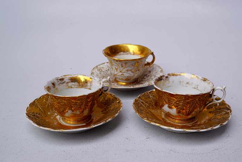 Königl. Meissen (Unterglasurblaue Marke, 19. Jhd.): Drei Tassen mit Reliefgolddekor