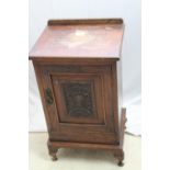 Edwardian oak bedside cabinet with decorative carved and panelled door with brass latch, one shelf