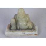 Carved stone Buddha on marble base