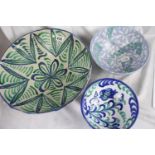 Three large glazed ceramic bowls , green/blue floral design