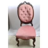 A very fine antique walnut lady's parlour chair; oval button back with carved surmount, carved