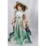 Doll on stand in green and flowered dress
