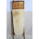 A vintage wooden ironing board with sleeve board
