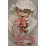 Doll on stand in white and pink dress with teddy